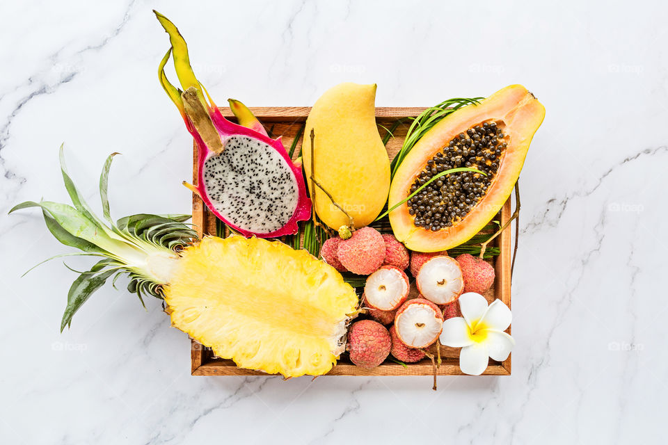 Wooden plate with fresh exotic fruits 