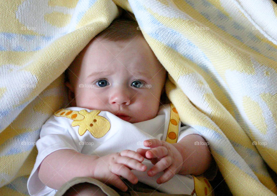 Portraits of the world, baby with blanket sliding onto his head