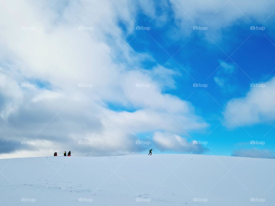 distant skiers ride the snowy ridge