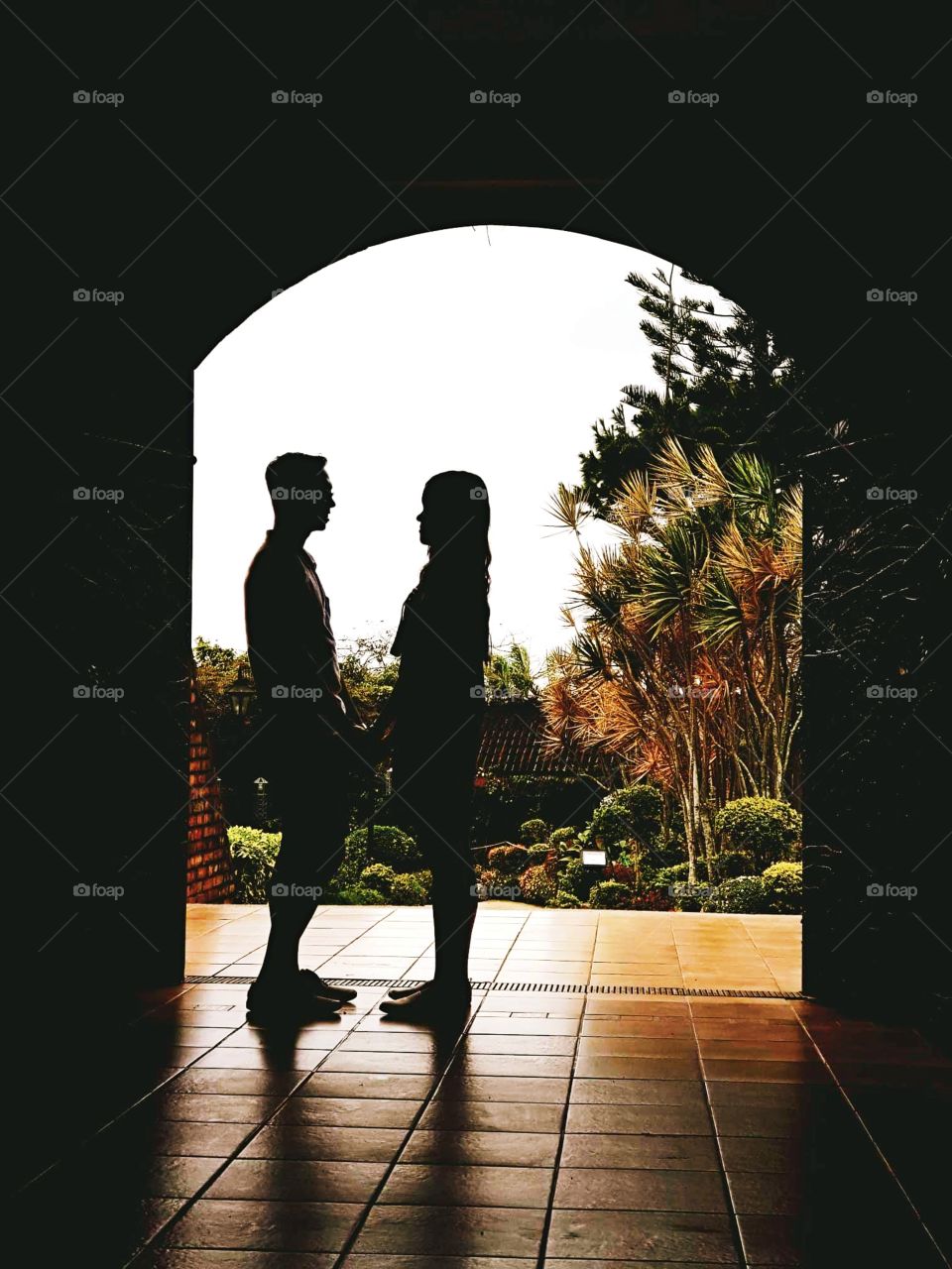 A standing, face to face silhouette of couple who was celebrating their first anniversary together.