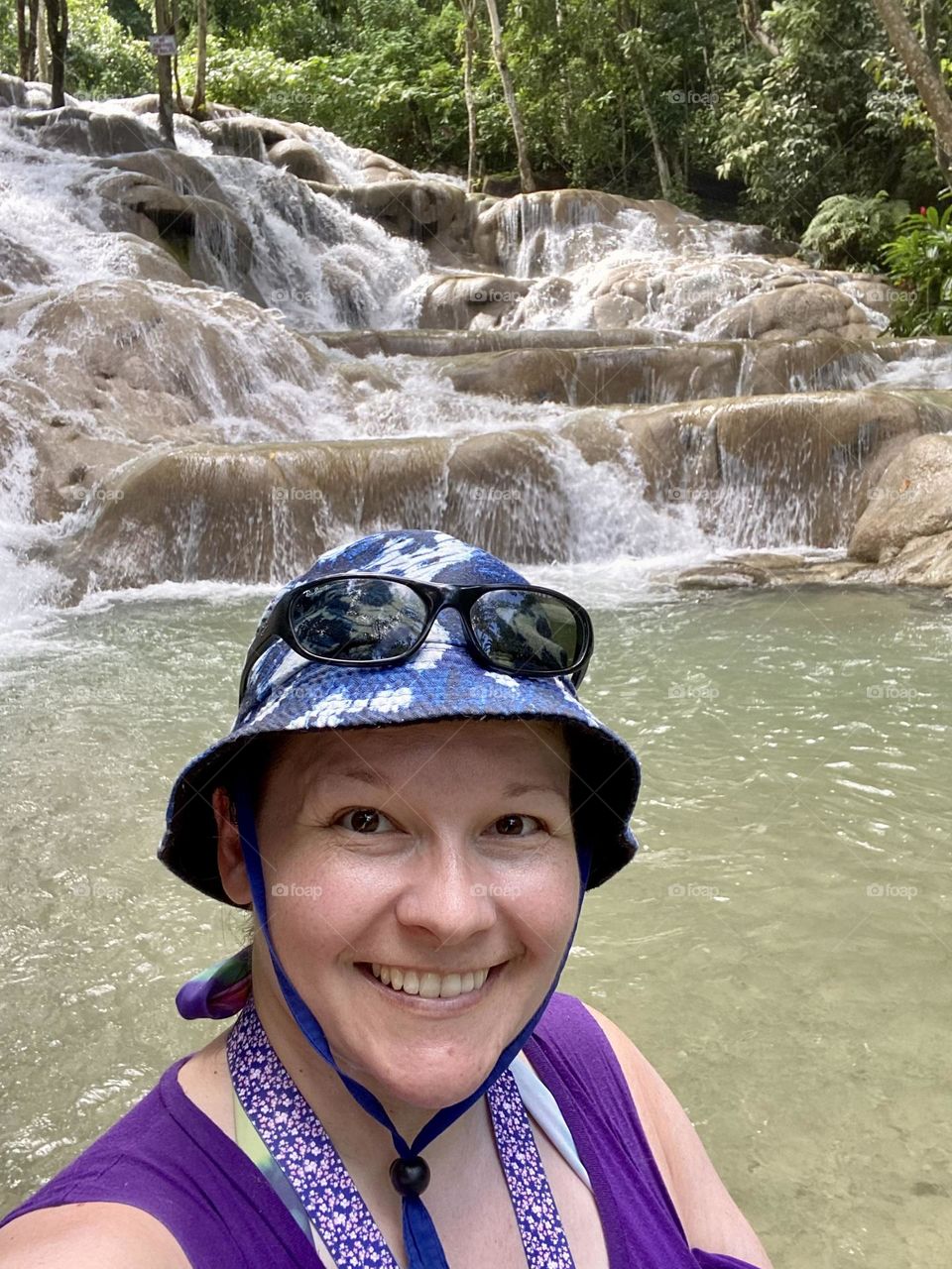A person standing in front of Dunns River Falls in Jamaica