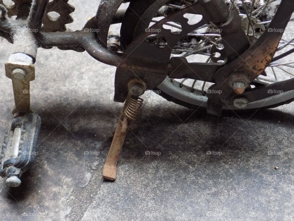 Old, rusty and broken toy bicycle