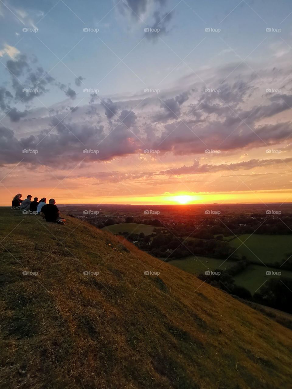 Let's go on a hike. Amazing sunset in Glastonbury, UK. Peoples enjoying the nice weather and beautiful scenery.