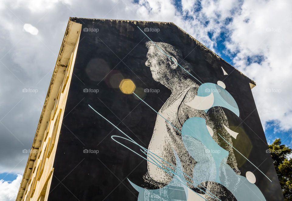Lens flare interacts with a large mural by Portuguese stencil artist Daniel Eime, entitled TEMP(L)O (2018) that is painted on the Pavilhão D. Nuno Álvares Pereira in Tomar, Portugal 
