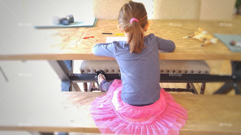 girl wearing a tutu and sitting at a table