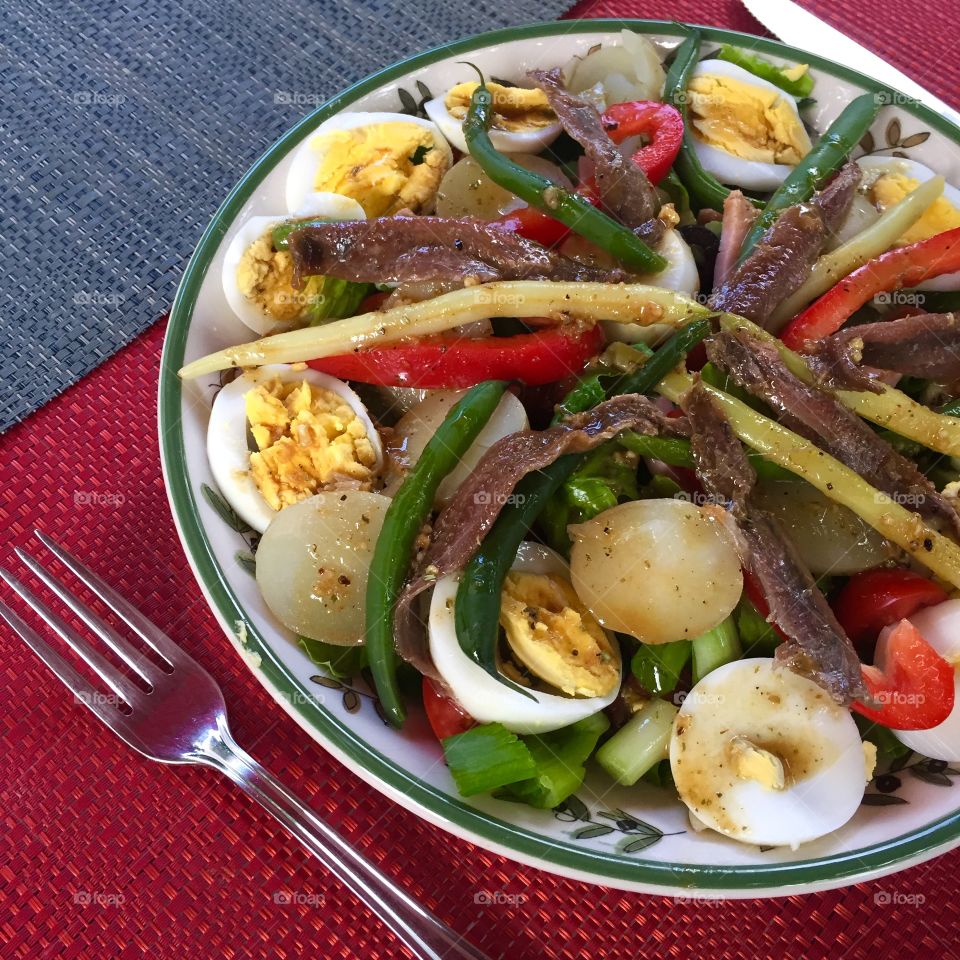 Salade Niçoise - colorful salad with eggs, green beans, potatoes, red pepper, cherry tomatoes, black olives. A healthy mediterranean receipe