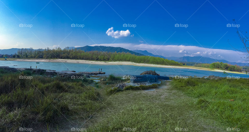 River and forest with beautiful mountains with clouds.