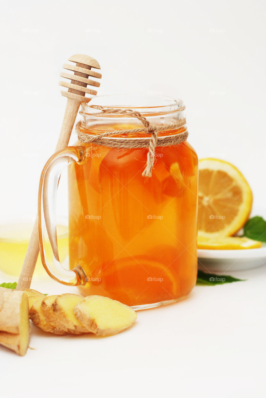 Ginger and lemon drink. Fruit citrus tea in glass jar honey dipper