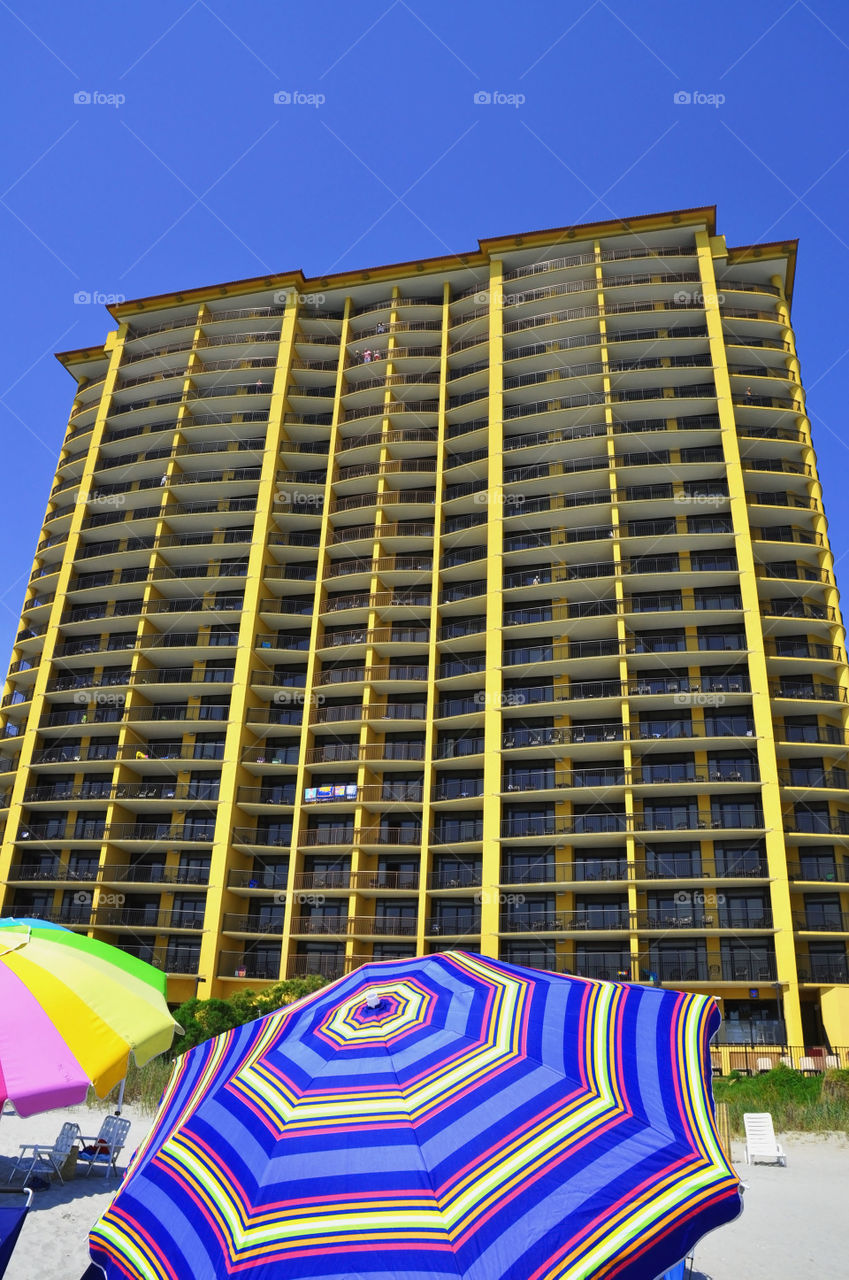 A large vacation condominium rises toward the sky. 