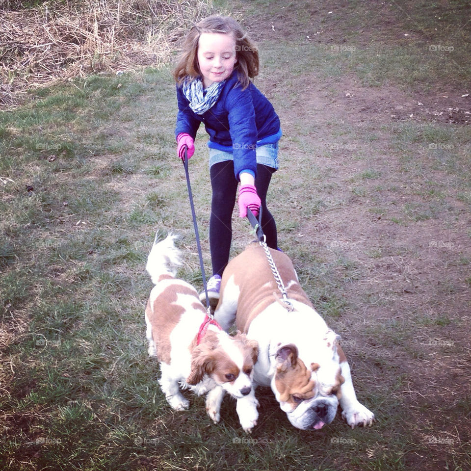 Girl getting walked by dogs