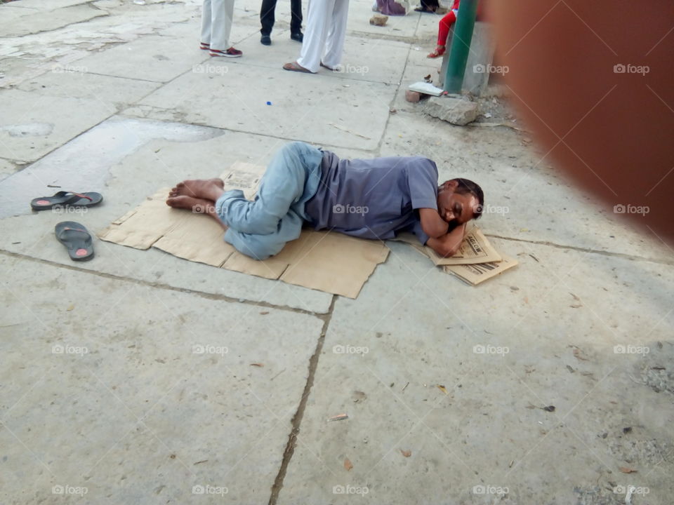 a poor person sleeping on floor.