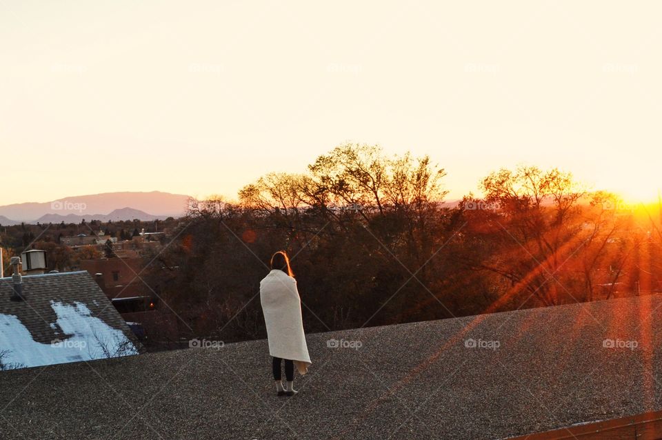 Girl standing on road during sunset