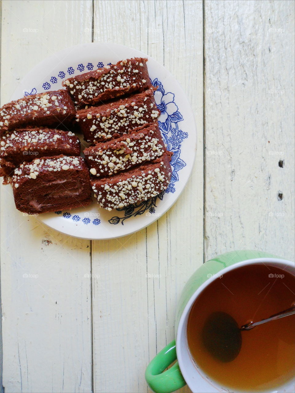 chocolate roll and a cup of black tea on a white background