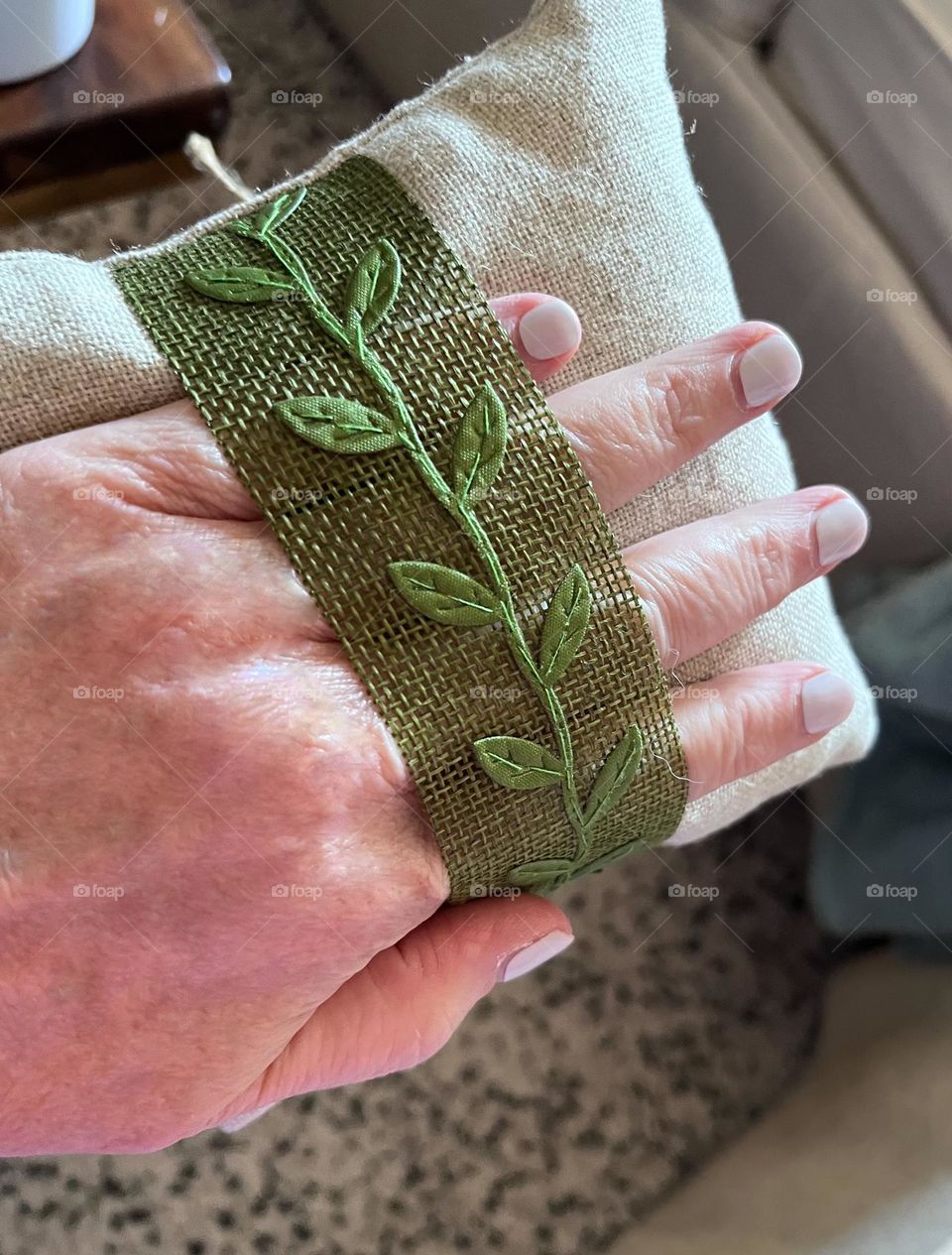 Backside of ring bearer’s pillow with green burlap ribbon and leaf trim. 