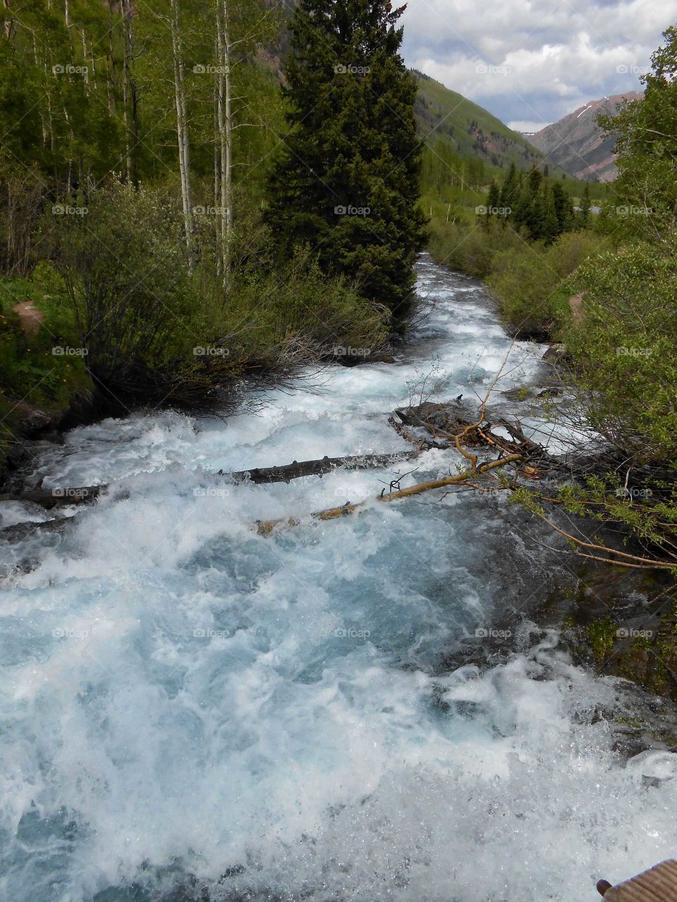 Spring runoff flows wild down Maroon Creek in the Colorado mountains.