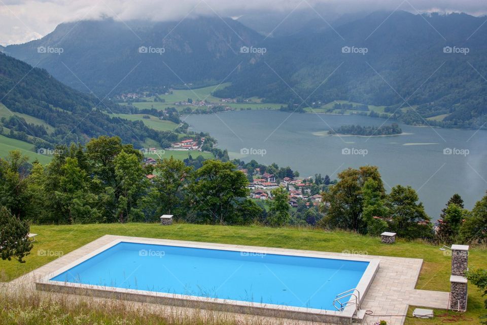 Swimming pool with a landscape view of mountains and lake