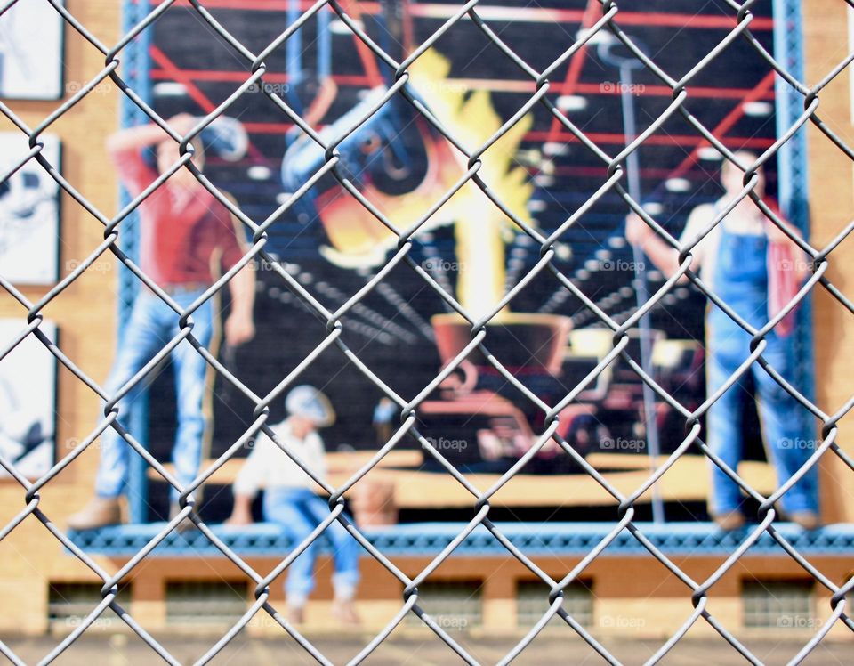 Steelworkers mural behind chain link fence