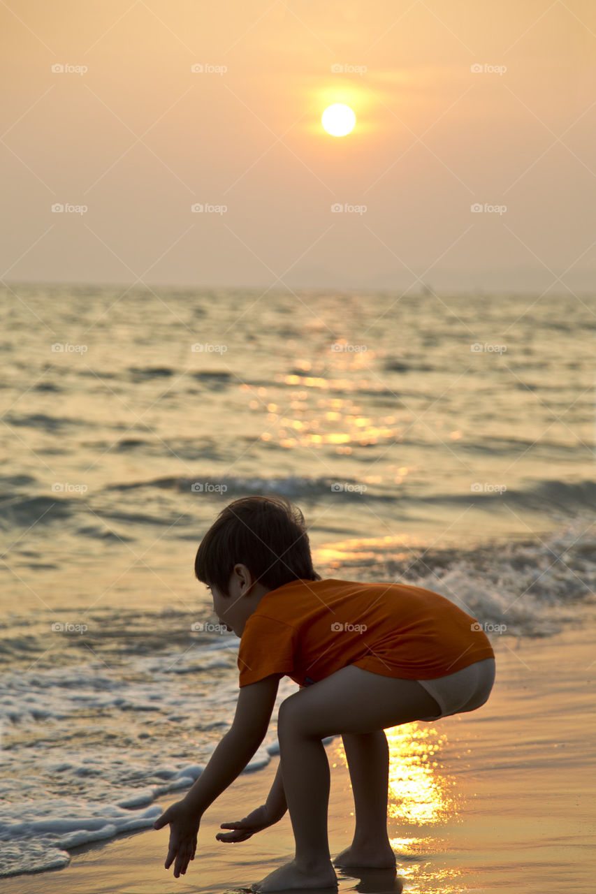 young boy playing on the beach 