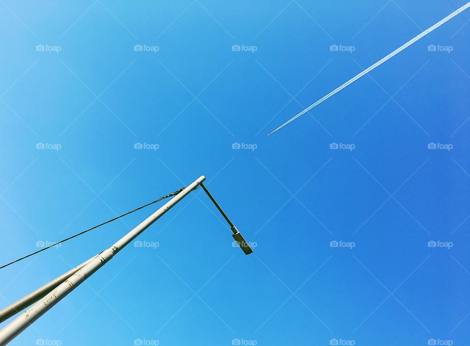 Competition in the sky. Lamp and plane joining one line the sky 