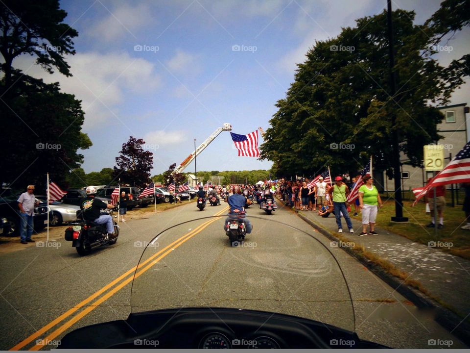 American Flag🇺🇲 hanging over road held up by Fire Trucks marking the start of a motorcycle ride. This ride was in memory of a fallen soldier in war.