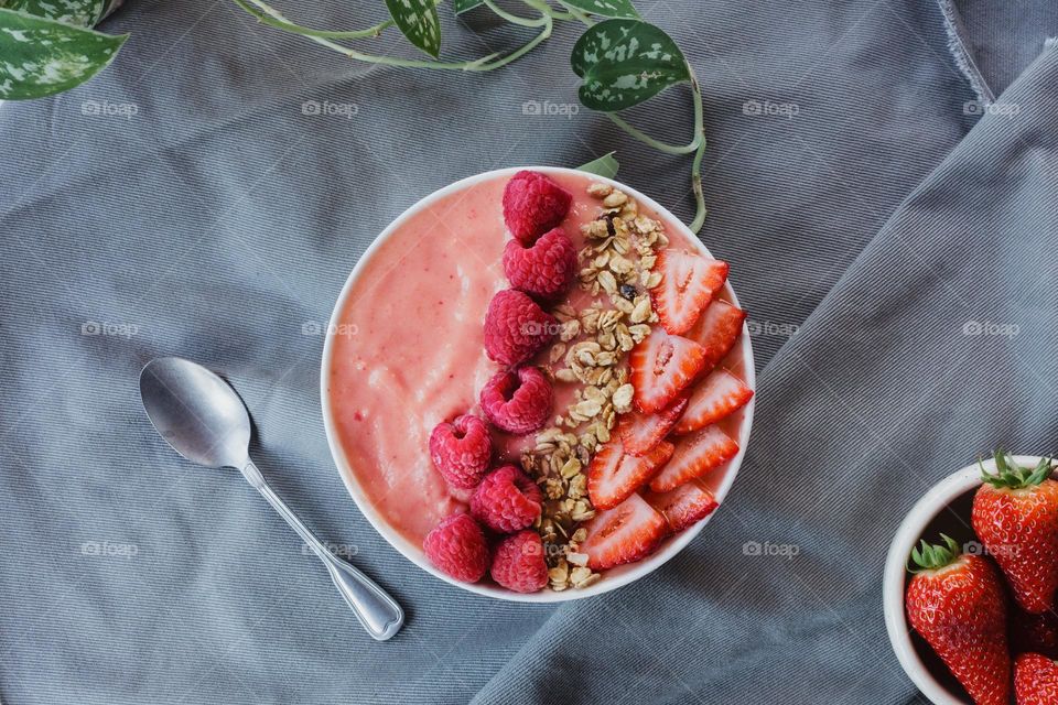 Strawberries and raspberries adorn this smoothie bowl as a morning snack.