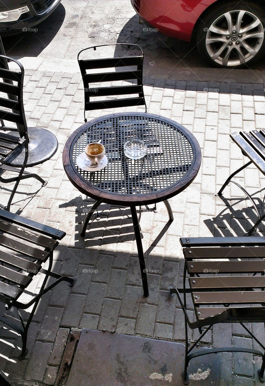 Empty cup of coffee on the table standing outside the cafe