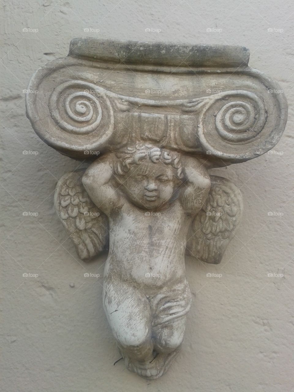 cherub. decorates our wall by the pool