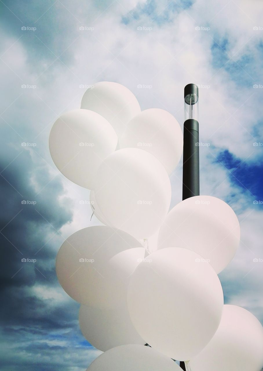 White balloons on the background of a summer stormy sky