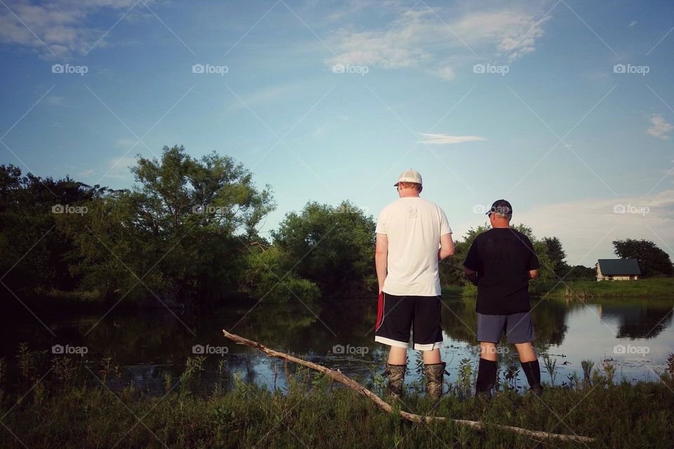 Two men looking at a pond