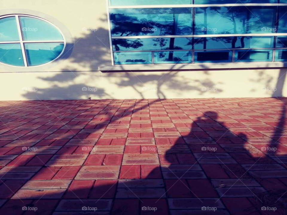 a shadow  of a child sitting  in the lap of her mother.