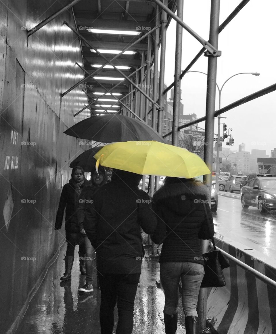 People walking with umbrellas on a rainy day in SOHO New York City 
