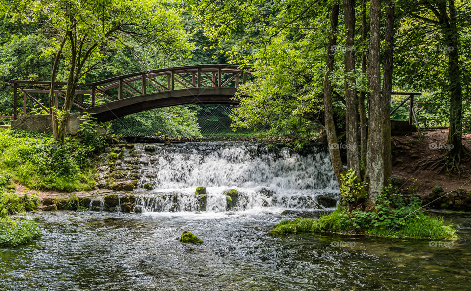 Wooden bridge over rivers waterfall