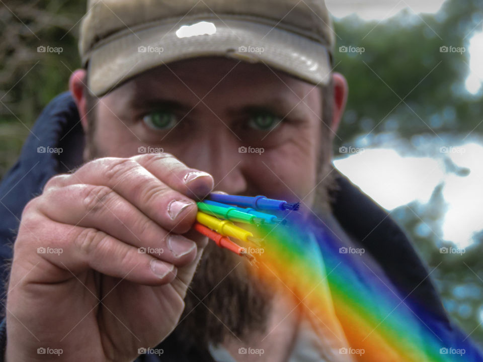 Man holding colorful brushes