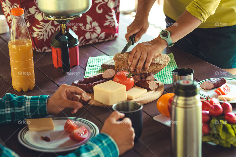 Preparing and eating a breakfast outdoor during spending vacation on camping