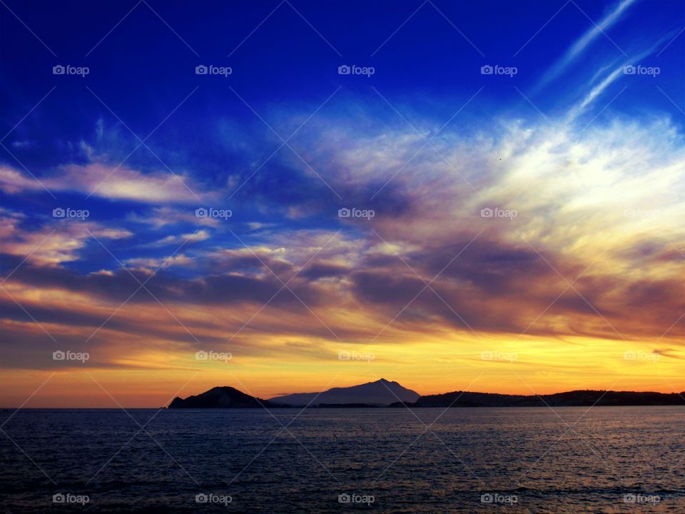 Clouds and yellow sun over Gulf of Naples ( Italy ).