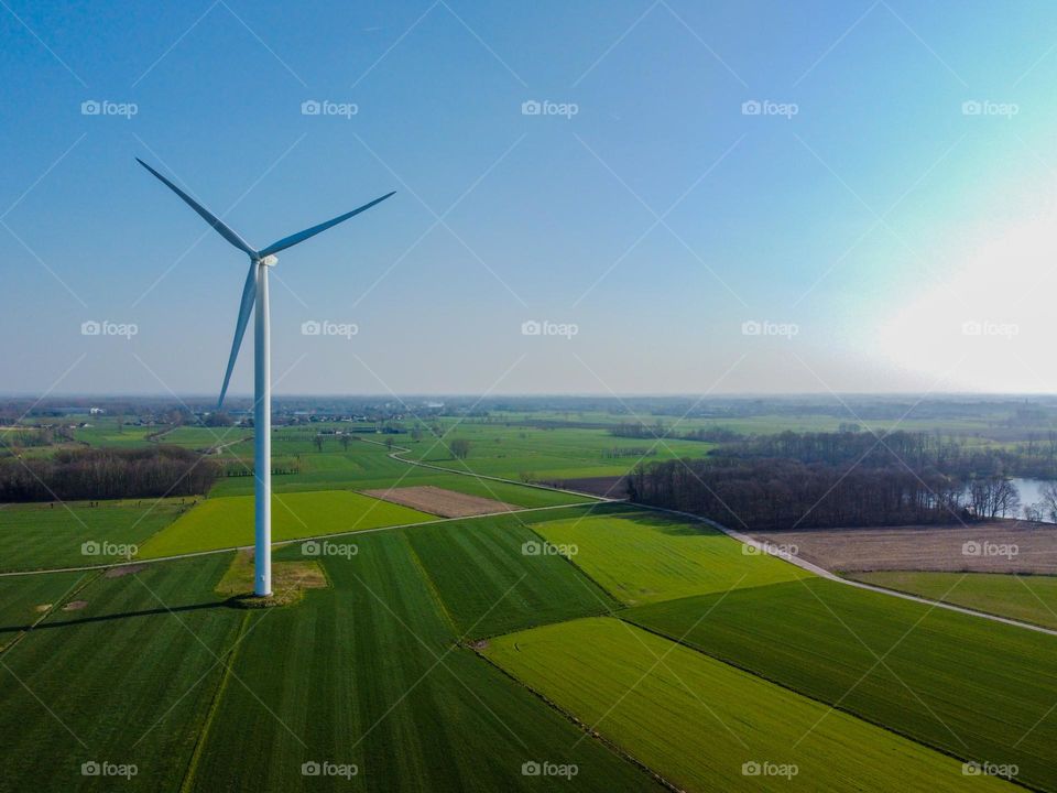 A windmill standing alone in the fields.