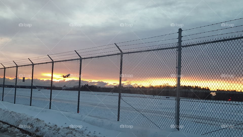 plane departing at sunrise. taken I'm portland maine during a winter sunrise