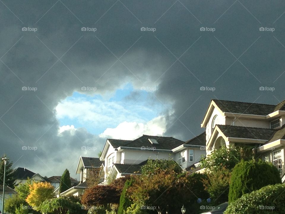 Stormy grey clouds with blue sky portal