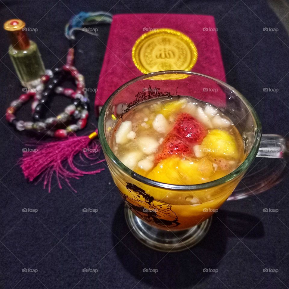 A glass of fruit drink (dinghy) for starters and fragrant prayer beads and the Holy Bible
