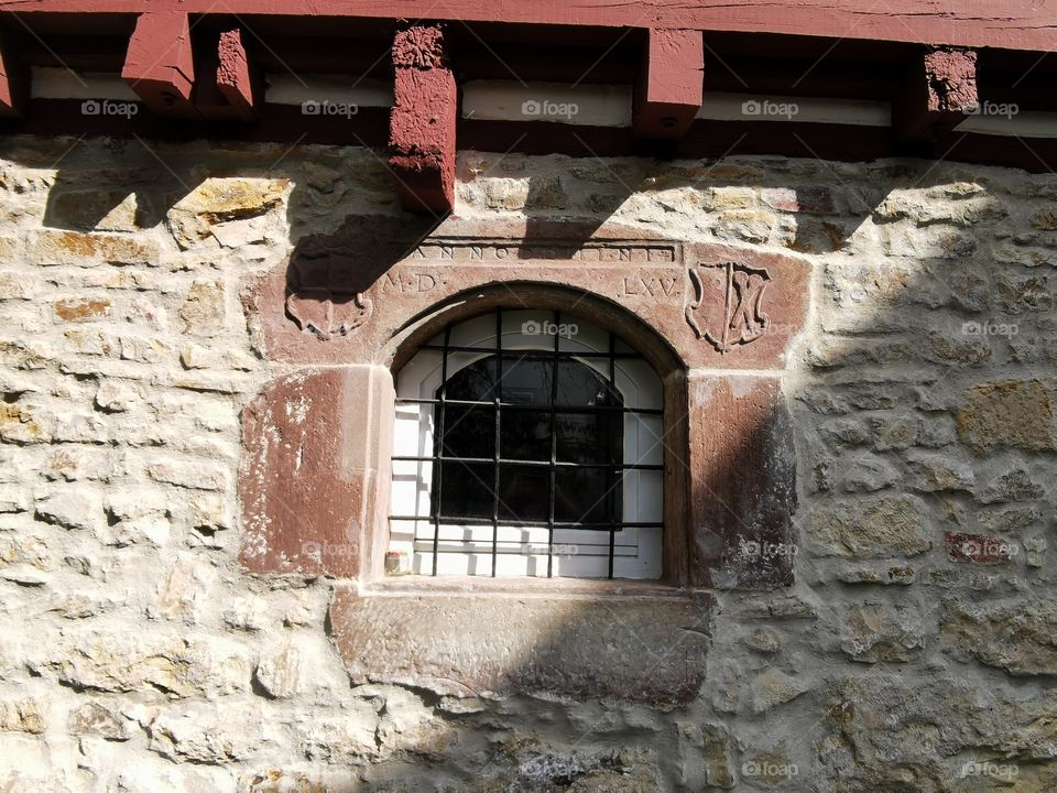 Vergittertes Fenster in einem alten Fachwerkhaus
