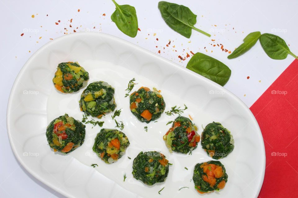 Spinach and carrots balls on a white plate.  Low calorie.  Top view of food