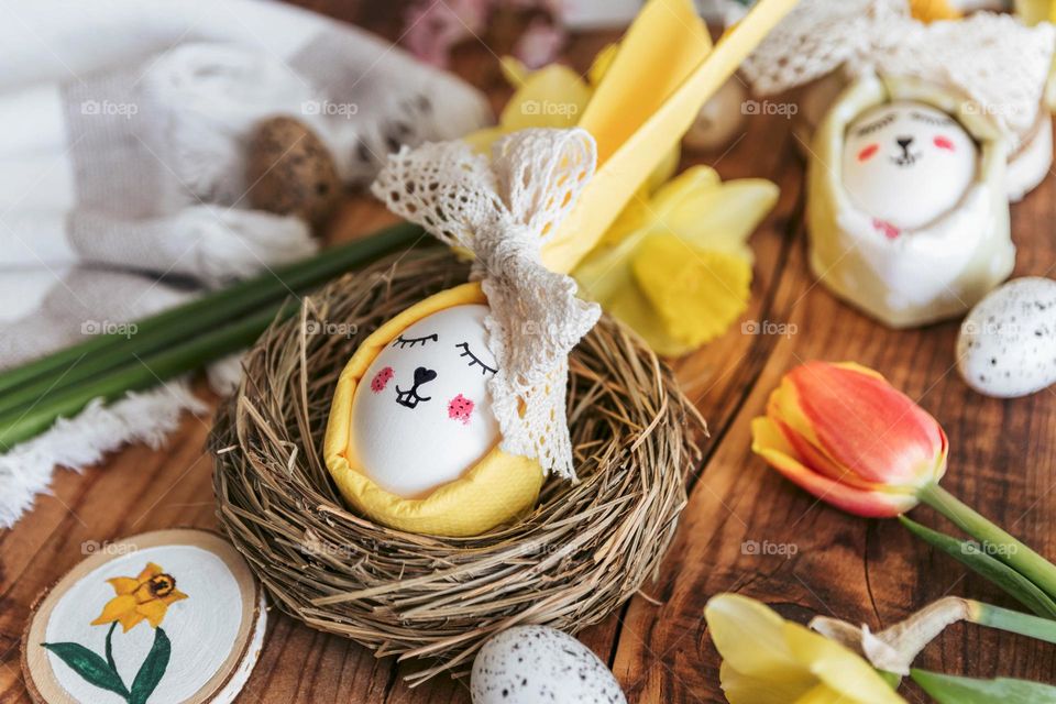 Close-up photo of easter egg decorated as a bunny in nest