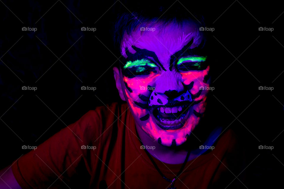 Neon makeup on a child, an angry tiger for Halloween
