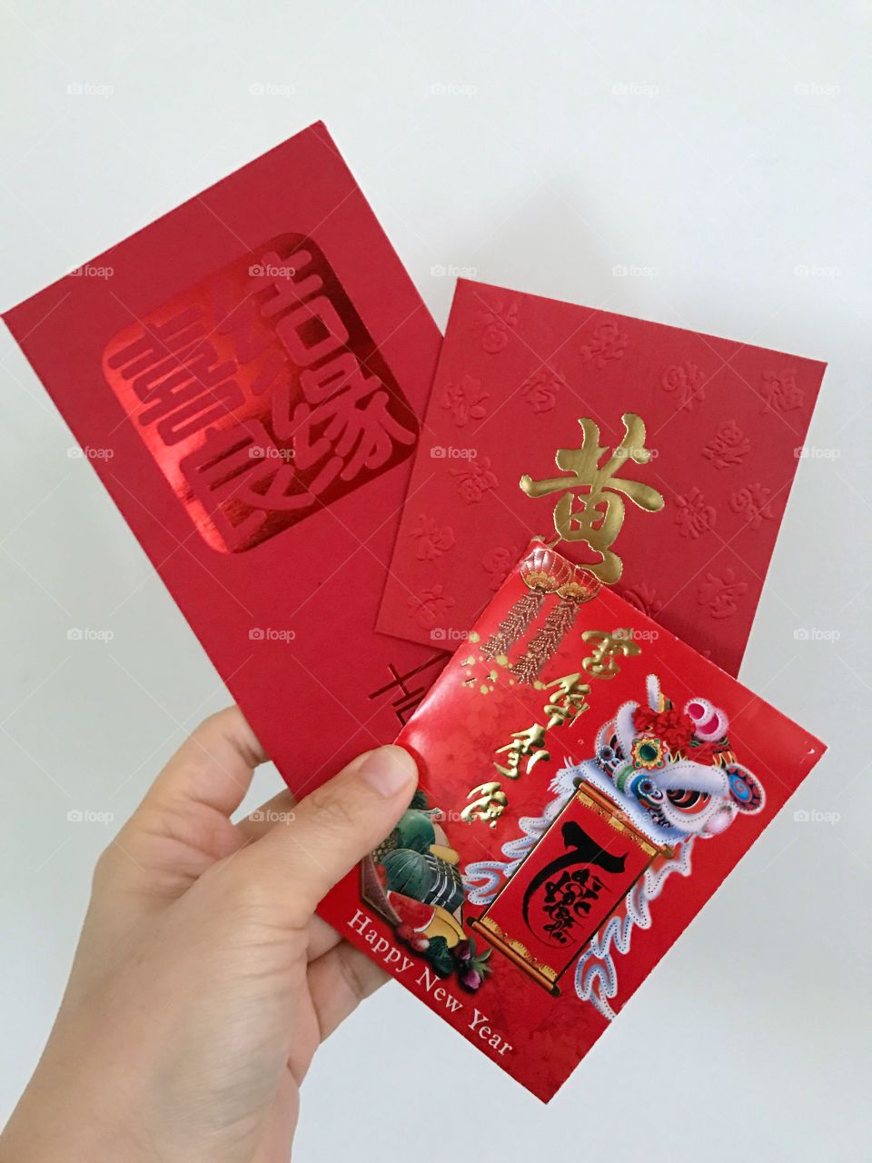 Hand holding Chinese New Year red envelopes 
