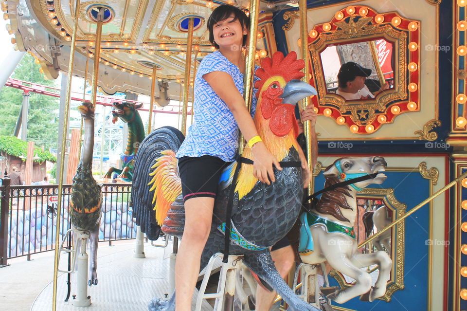 Summertime is for amusement parks! My daughter & my husband were riding this beautiful Carousel. The beautiful figures were all hand carved by a local company. My daughter rode the rooster & her dad reflected in the mirror rode a pretty pony. ðŸŽ