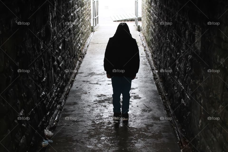 Hooded teen in an underground tunnel