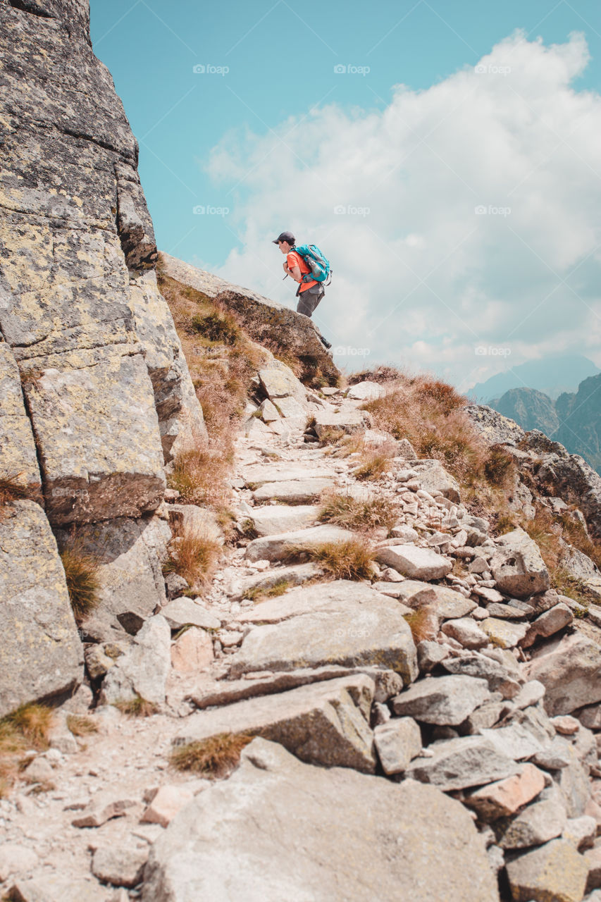 Young man hiking on the rocky mountain