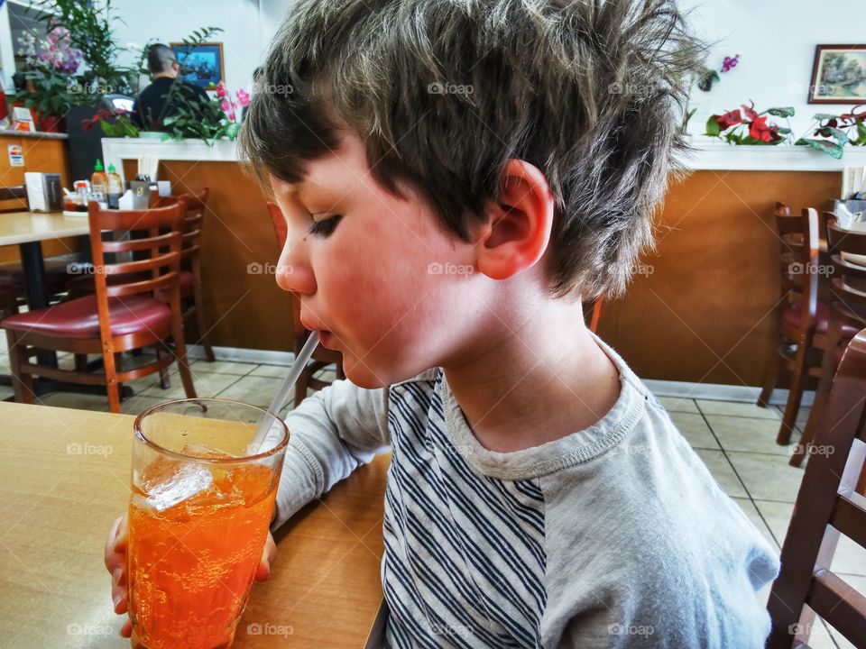 Young Boy Drinking Orange Soda