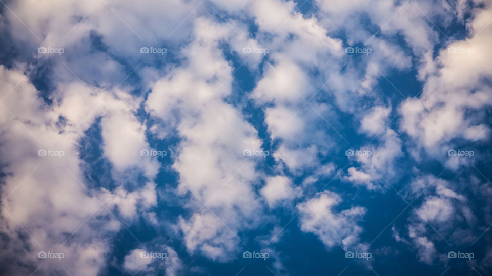 Large clouds float across the sunset sky like sails.