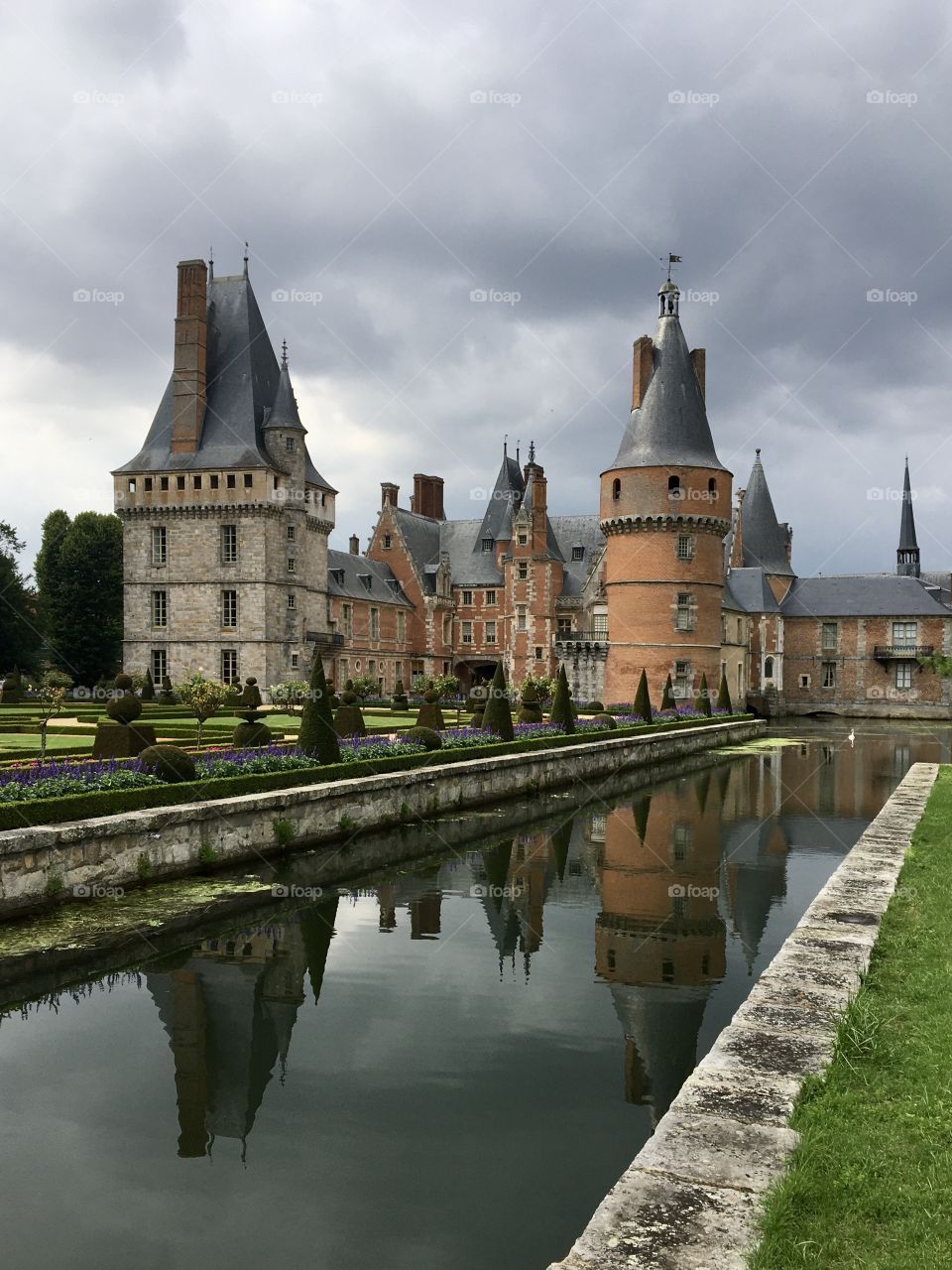 Old classical castle with clouds and mirror in water 